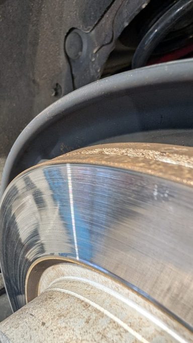 Bremsbelag und Bremsscheibe eines Fahrzeugs, nah aufgenommen mit Fokus auf die Oberfläche.